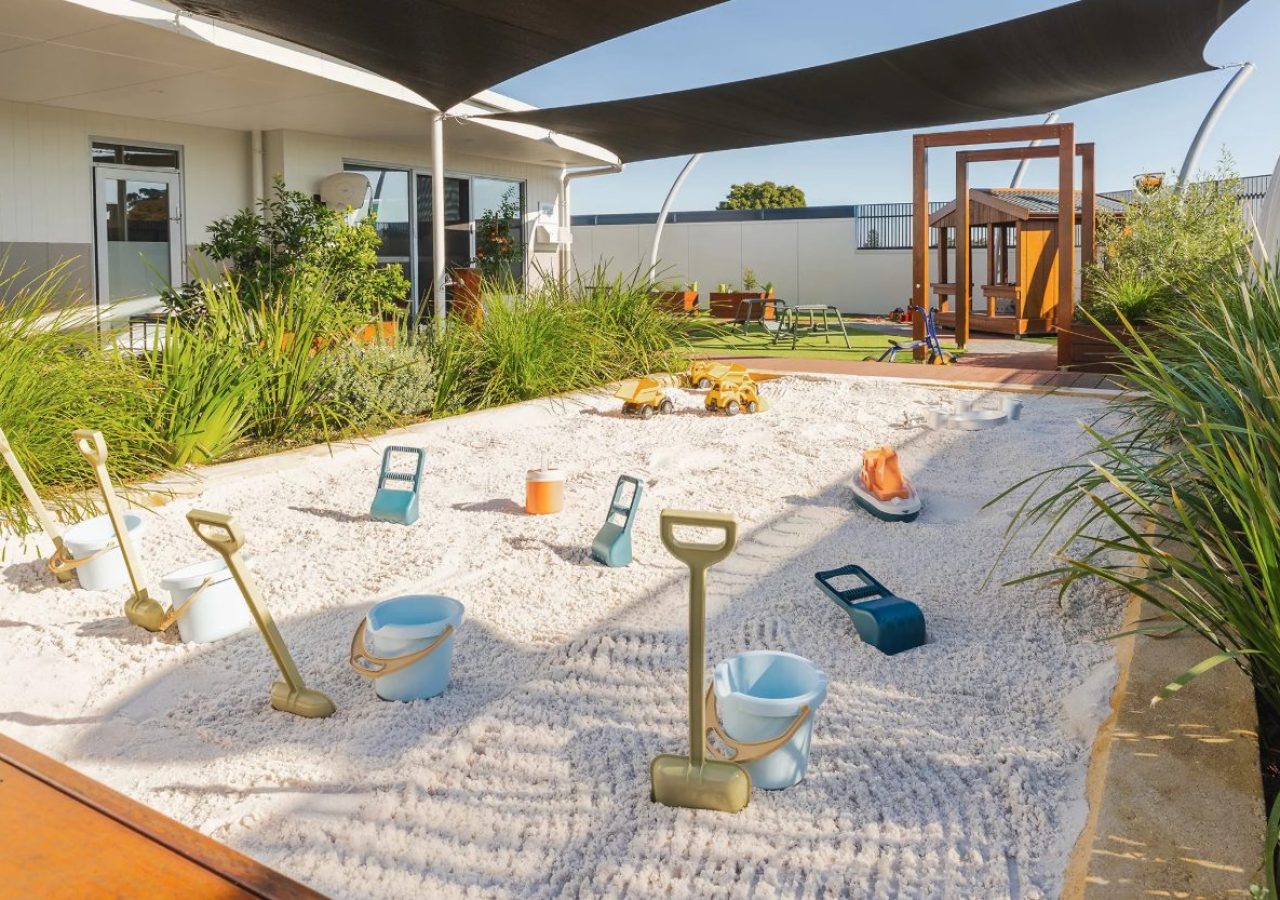 Kewdale Early Learning Centre landscaping - sandpit with dig toys and native grasses