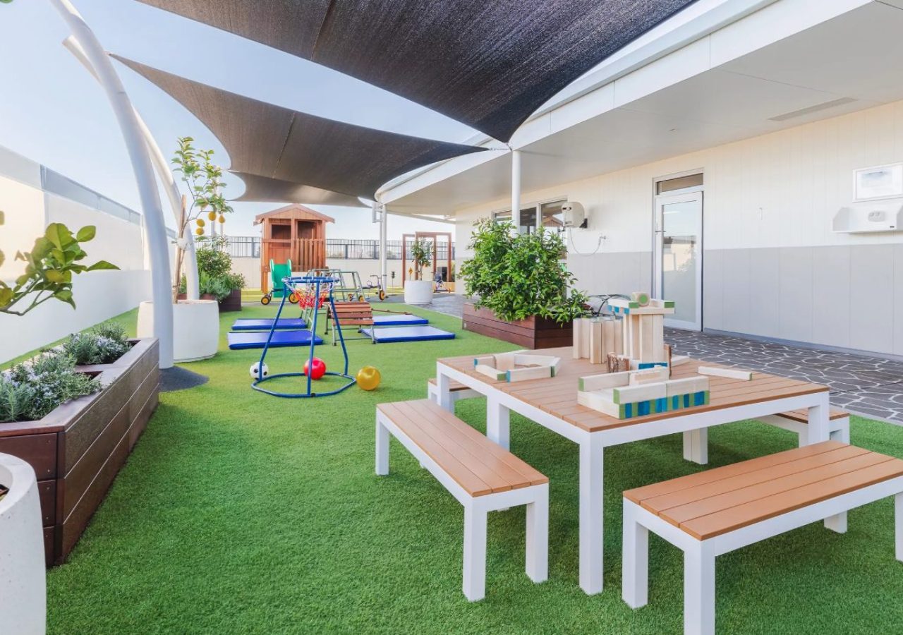 Kewdale Early Learning Centre landscaping - outdoor play area with timber tables and play equipment